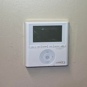 Lennox thermostat installed on a wall, showcasing modern temperature control features for HVAC systems in Hidalgo County.