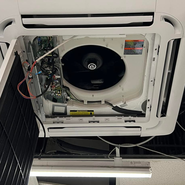 Ceiling-mounted air conditioning unit showing internal components, including fan and wiring, illustrating HVAC maintenance and repair services by L&S Air LLC in the Rio Grande Valley.
