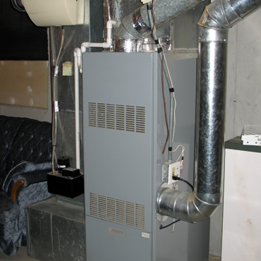Heating system in a residential setting, showcasing a gray furnace with ductwork, emphasizing HVAC repair and maintenance services in Rio Grande Valley.