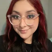 Stephanie Olivas, Office Manager at L&S Air LLC, smiling with red and black hair, wearing stylish glasses, reflecting a positive attitude and commitment to customer service.